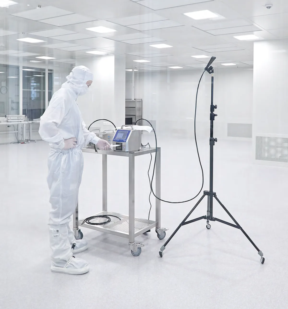 Technician in cleanroom clothing taking measurements in a cleanroom